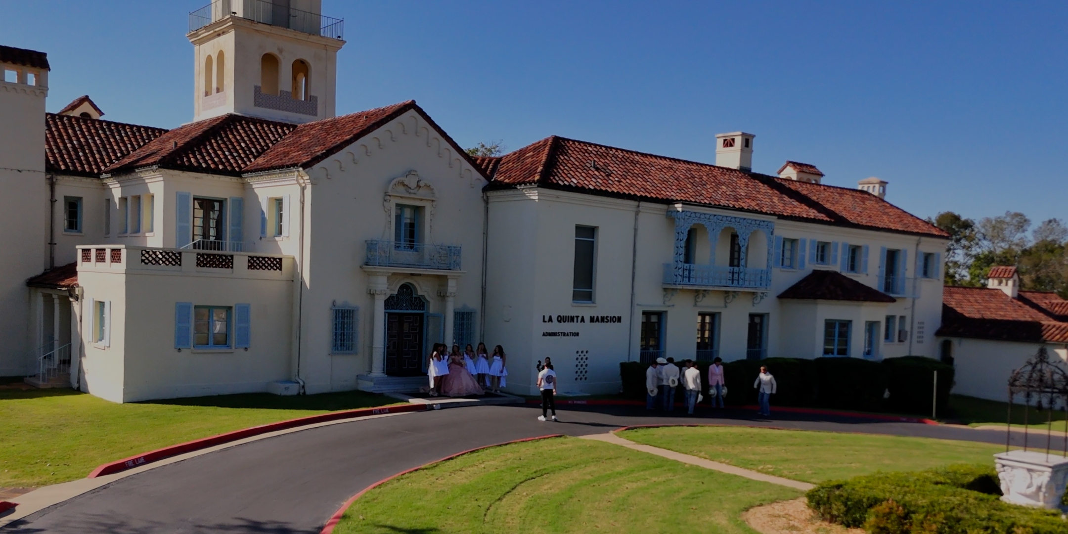 Wide aerial view of outdoor event venue with guests during golden hour