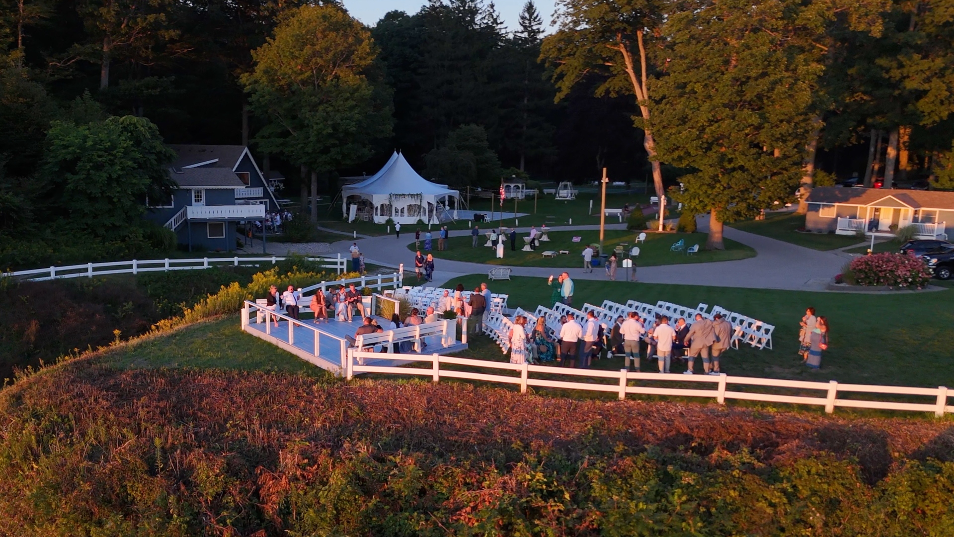 Golden hour aerial drone view of outdoor event at Michillinda Lodge on White Lake, Michigan